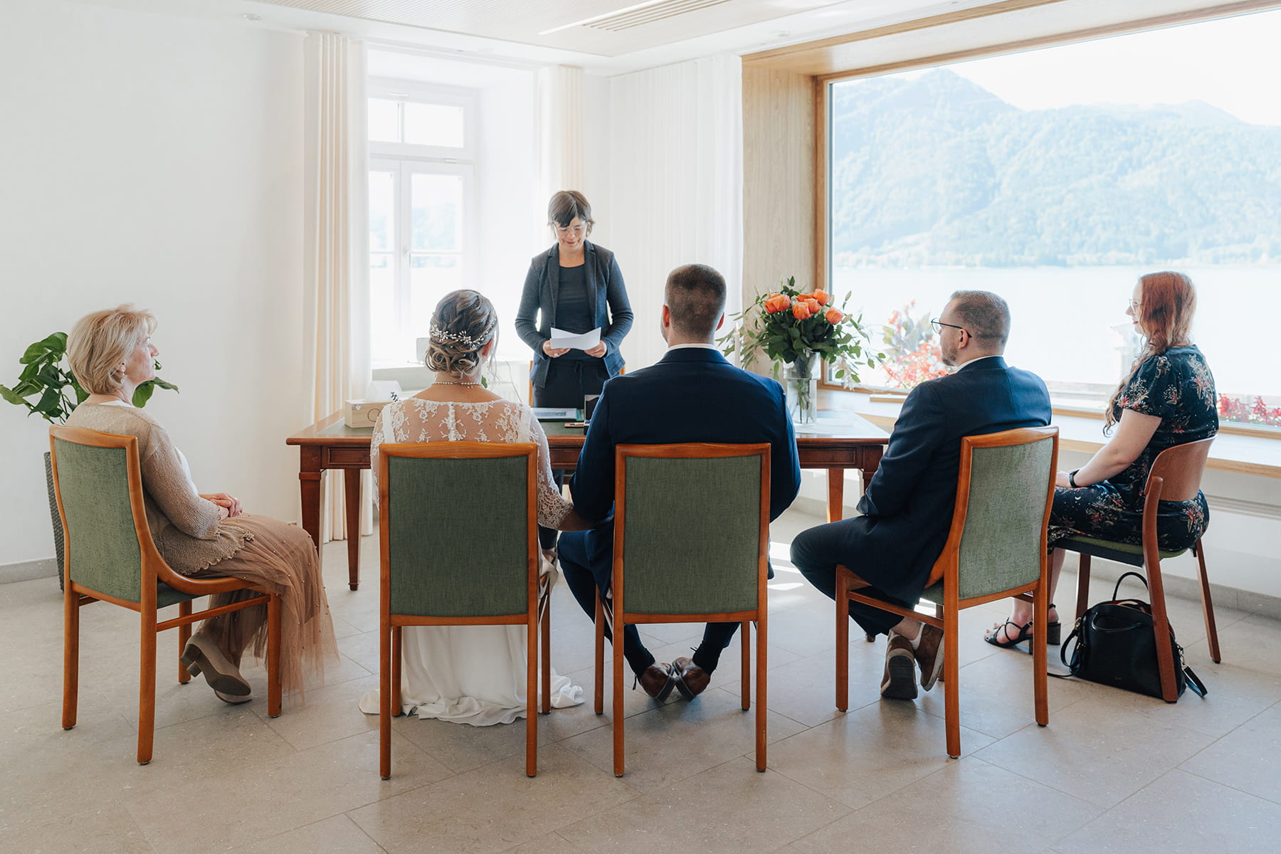 Hochzeitsfotograf Tegernsee, Rathaus Tegernsee, Hochzeit Tegernsee, Standesamt Tegernsee, Brautpaar, Fröhlich, Lachen, Hochzeitsgesellschaft, Trauung Tegernsee, Rückansicht