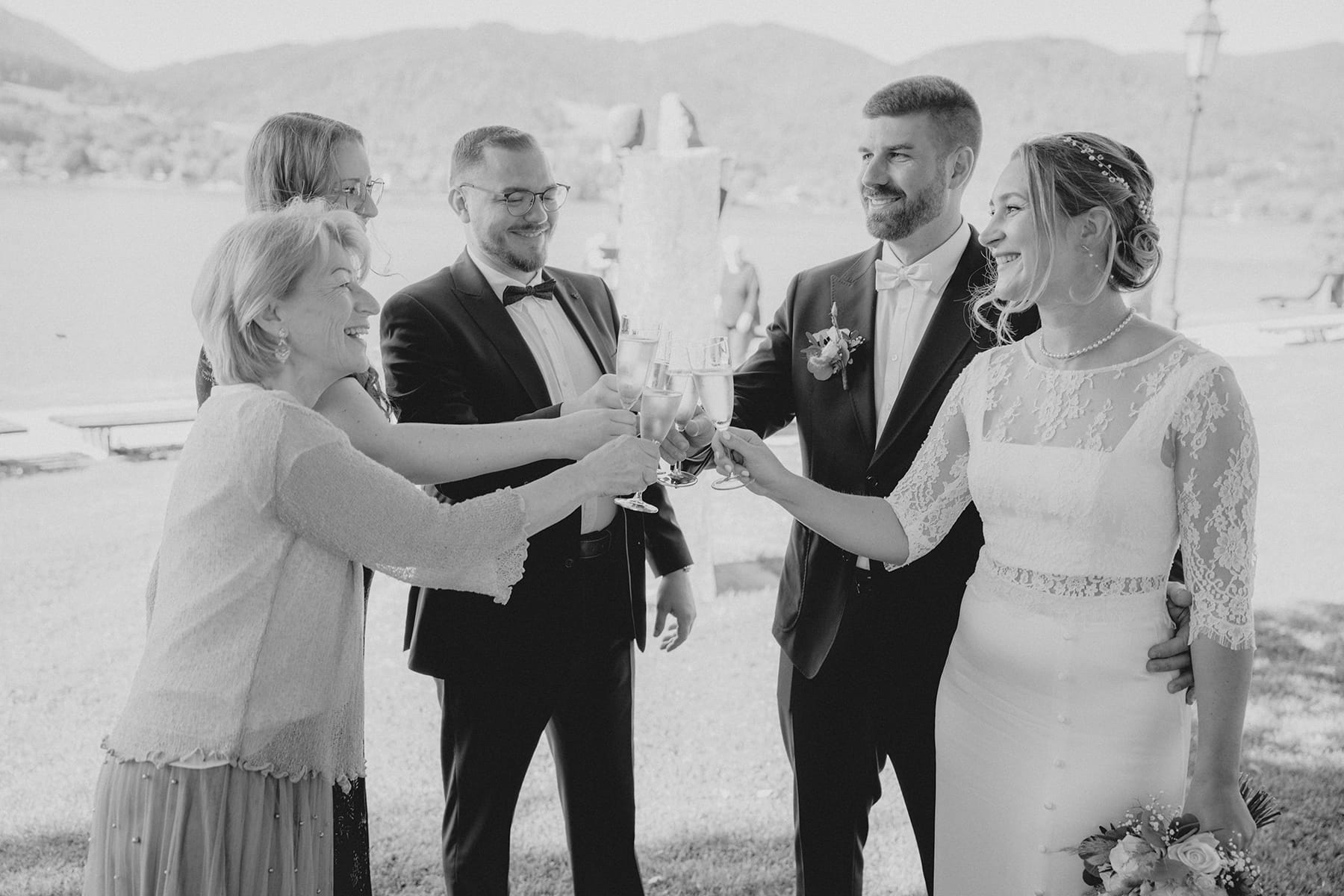 Hochzeitsfotograf Tegernsee, Rathaus Tegernsee, Hochzeit Tegernsee, Standesamt Tegernsee, Brautpaar, Fröhlich, Lachen, Hochzeitsgesellschaft, Trauung Tegernsee, Anstoßen, Sekt, Sektglas, Champagner