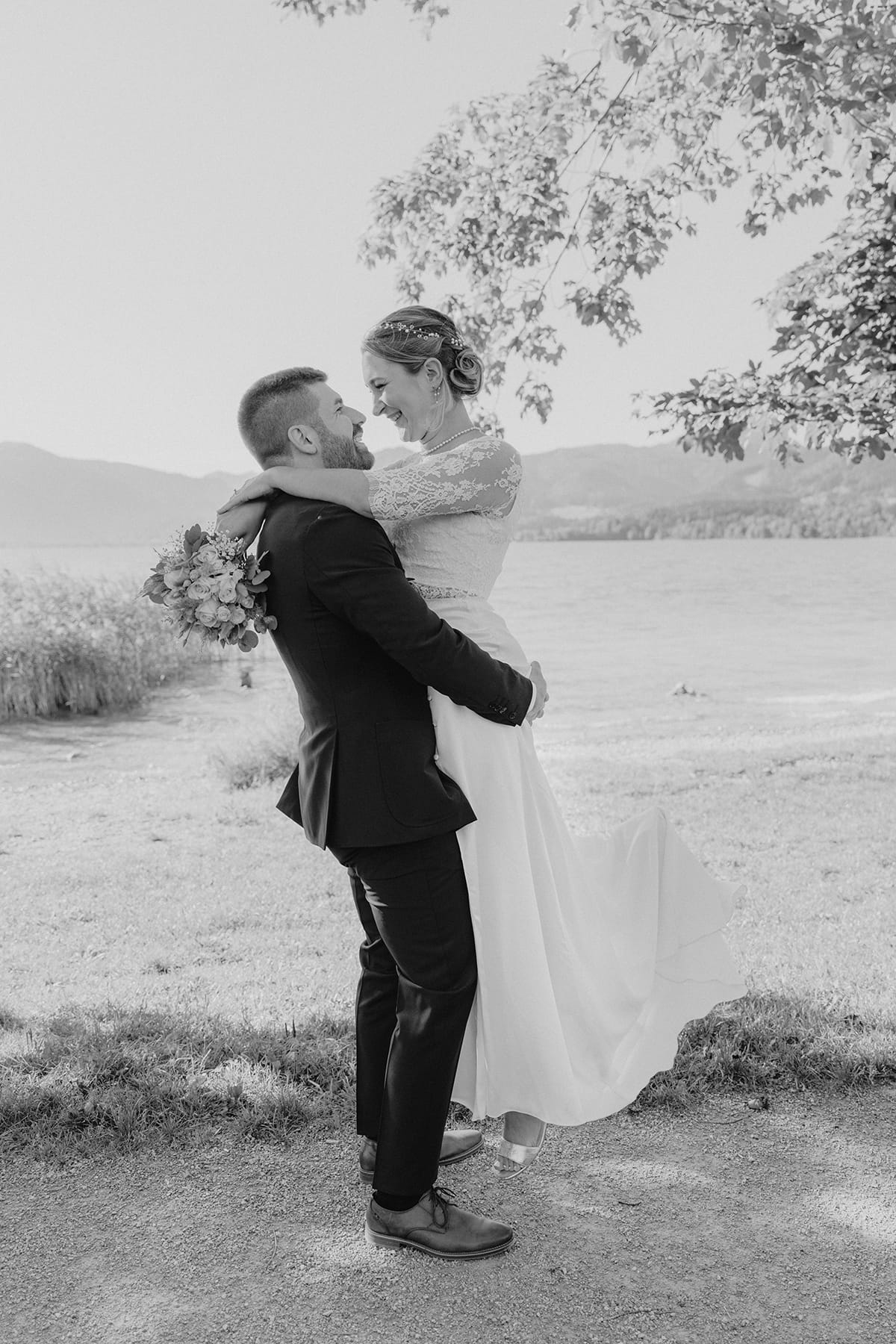 Hochzeitsfotograf Tegernsee, Rathaus Tegernsee, Hochzeit Tegernsee, Standesamt Tegernsee, Brautpaar, Fröhlich, Lachen, Hochzeitspaar, Trauung Tegernsee, Brautstrauß, Blumenstrauß, Brautkleid, Bräutigam, Umarmung, Brautpaarshooting, Hebefigur